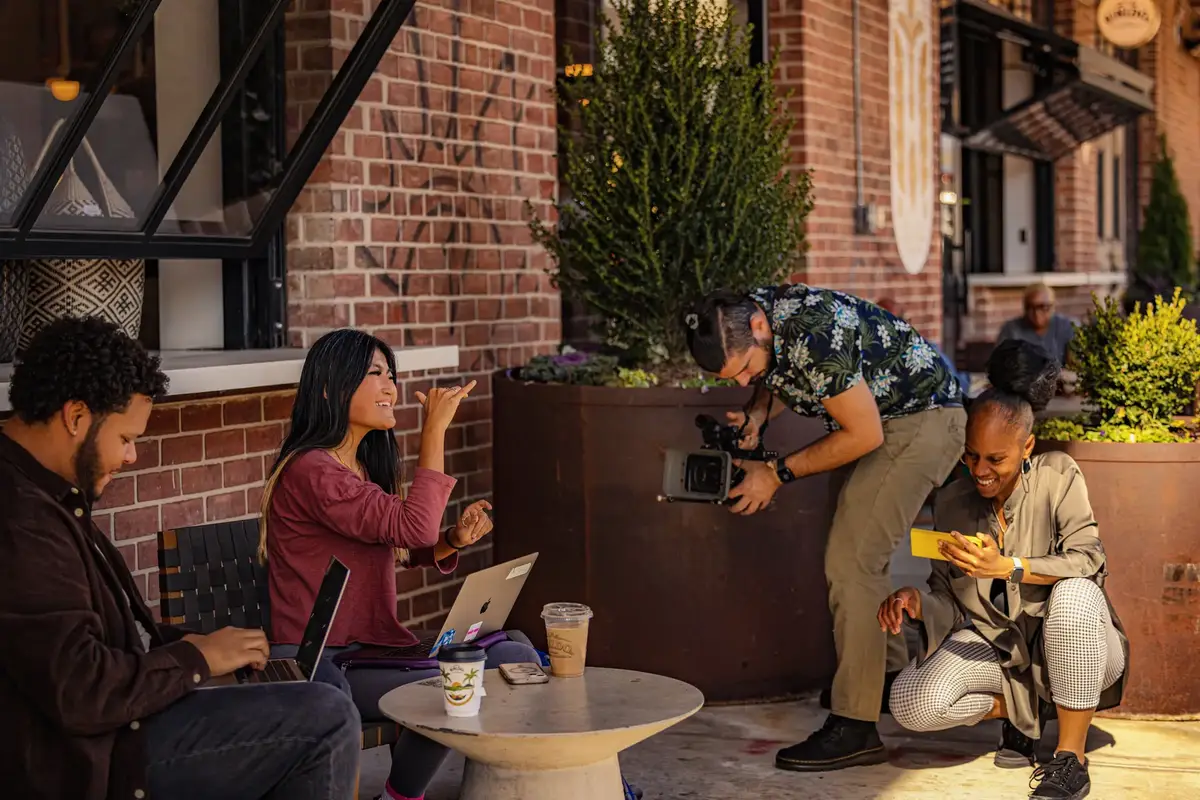 Javier filming an interview on location at an outdoor cafe