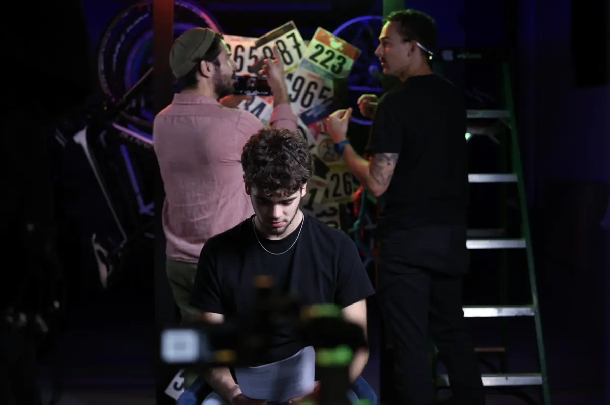 Crew and talent reviewing a script on a colorful set between takes