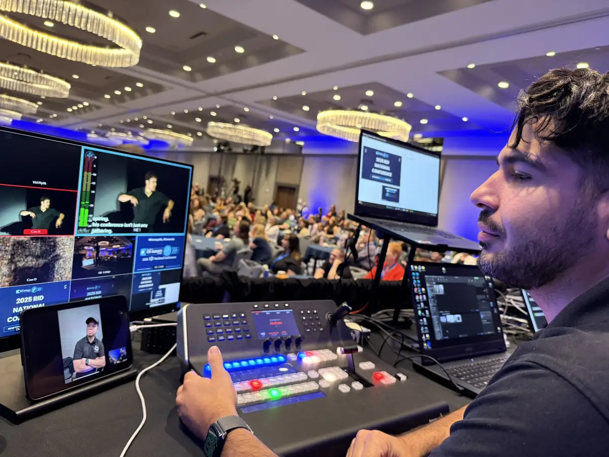 Javier at a live video switcher with an ASL interpreter on the program feed at the RID National Conference