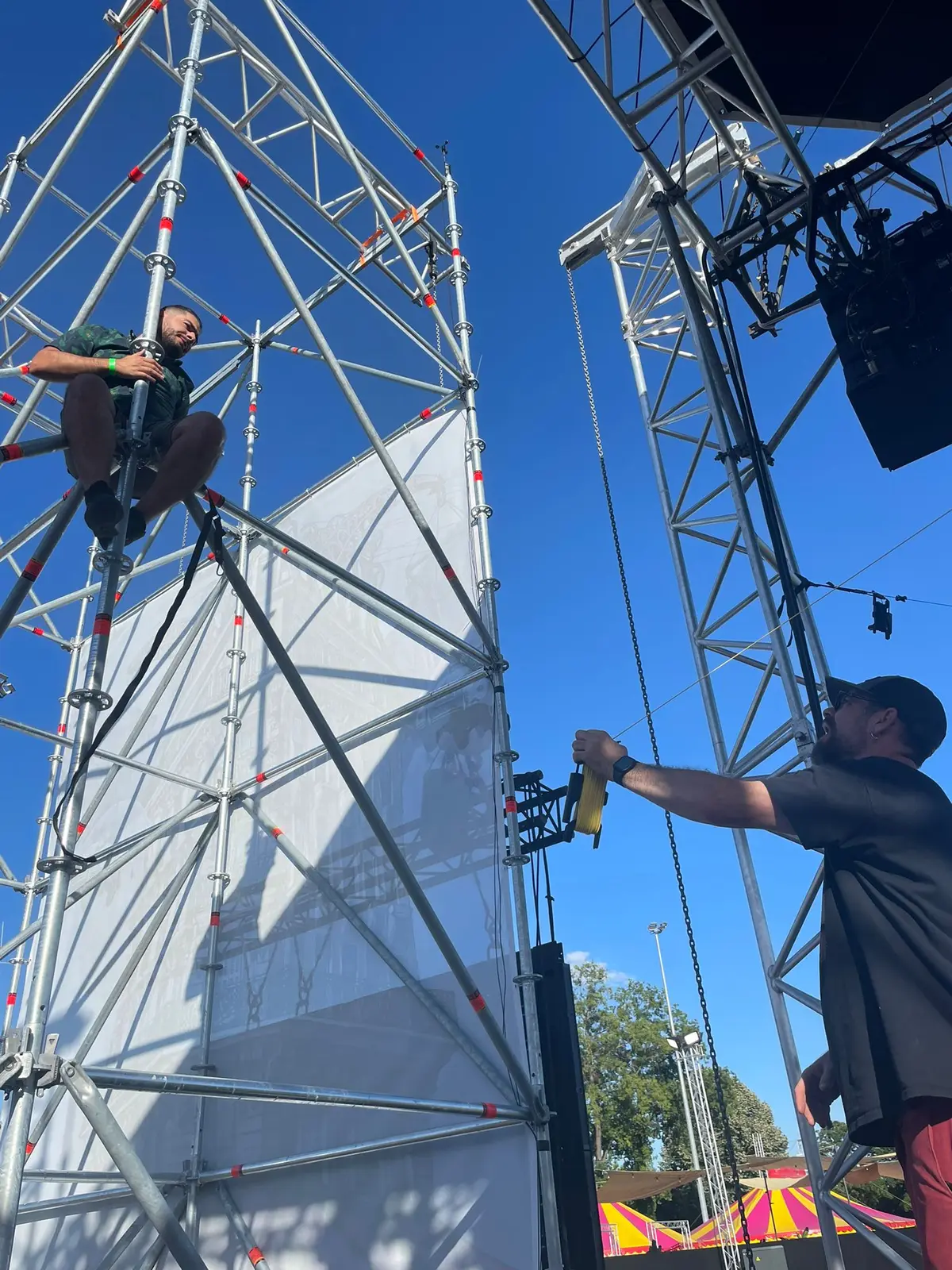 Javier rigging a screen tower at an outdoor live event