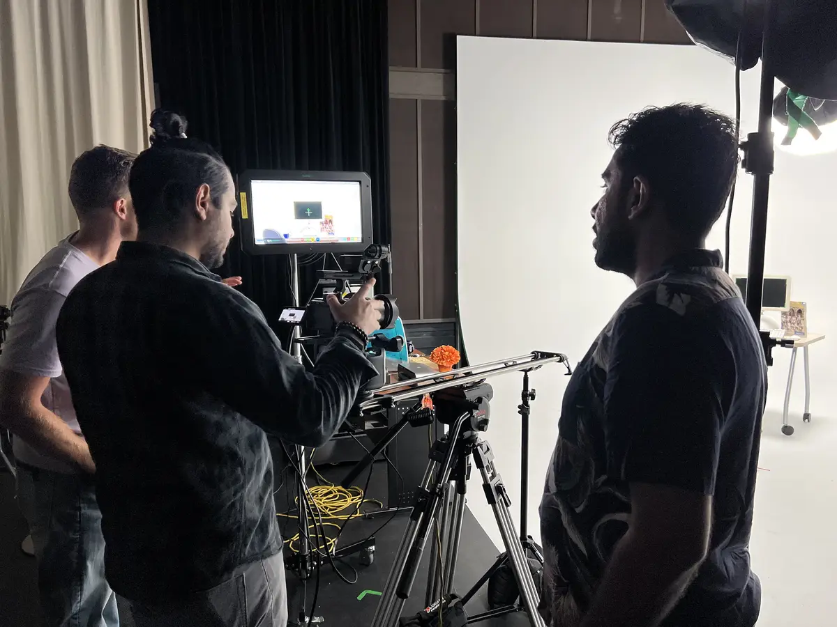 Javier directing a slider shot with crew in studio